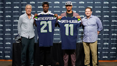 Seattle Seahawks head coach Pete Carroll, from left, poses with first-round NFL football draft picks Devon Witherspoon, a cornerback from Illinois, and Jaxon Smith-Njigba, a wide receiver from Ohio State, along with general manager John Schneider, Friday, April 28, 2023, during a press conference at the team's headquarters in Renton, Wash. (AP Photo/Lindsey Wasson)