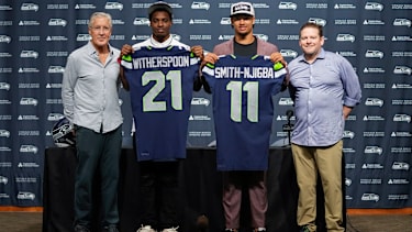 Seattle Seahawks head coach Pete Carroll, from left, poses with first-round NFL football draft picks Devon Witherspoon, a cornerback from Illinois, and Jaxon Smith-Njigba, a wide receiver from Ohio State, along with general manager John Schneider, Friday, April 28, 2023, during a press conference at the team's headquarters in Renton, Wash. (AP Photo/Lindsey Wasson)