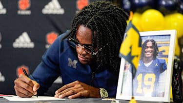 Bryce Underwood poses for a photo as he signs for Michigan football on during national signing day