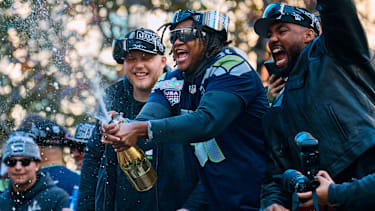 Jared Ivey (51) von den Seattle Seahawks öffnet während der Super-Bowl-Siegesparade am 11. Februar 2026 in Seattle eine Flasche Champagner.