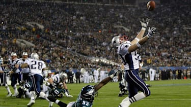 New England Patriots linebacker Mike Vrabel (50) hauls in a third quarter touchdown pass as Philadelphia Eagles linebacker Jevon Kearse (93) defends during Super Bowl XXXIX at Alltel Stadium.
