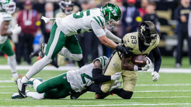Dec 21, 2025; New Orleans, Louisiana, USA;  New Orleans Saints tight end Juwan Johnson (83) is tackled by New York Jets safety Dean Clark (35) during the first half  at Caesars Superdome. Mandatory Credit: Stephen Lew-Imagn Images