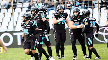 Spieler der Munich Ravens jubeln während des Spiels gegen die Raiders Tirol im Grünwalder Stadion in München (European Football Alliance, Deutschland)
