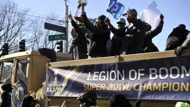 Seattle s Richard Sherman shows off the Lombardi Trophy as the rest of the Legion of Boom wave to the 12th Man at the Seattle Seahawks Super Bowl victory parade in Seattle, Washington.