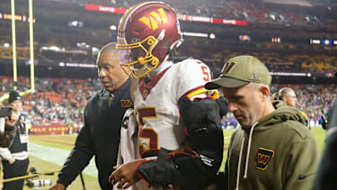 Quarterback Jayden Daniels (5) von den Washington Commanders wird nach einer Verletzung in der zweiten Halbzeit gegen die Seattle Seahawks vom Feld begleitet.