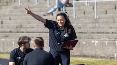 Defensive Analystin Nadine Nurasid zeigt mit Laptop eine Richtung beim GFL-Spiel zwischen den Munich Cowboys und den Schwäbisch Hall Unicorns (American Football, Deutschland)