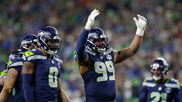 Leonard Williams 99 of the Seattle Seahawks encourages crowd noise while standing at the line of scrimmage before a play during the NFC Championship game