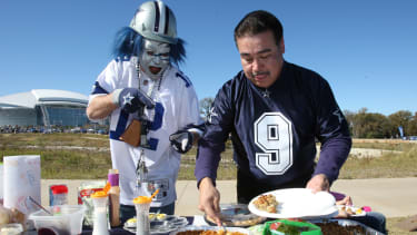 Nov 26, 2009; Arlington, TX, USA; Dallas Cowboys fans prepare a plate of food for Thanksgiving while tailgating outside Cowboys Stadium. Mandatory Credit: Matthew Emmons-Imagn Images