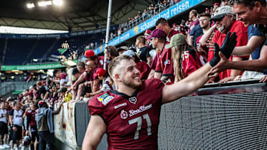 2023 klatscht Leander Wiegand mit den Fans von Rhein Fire ab.