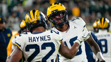 Oct 25, 2025; East Lansing, Michigan, USA; Michigan Wolverines running back Justice Haynes (22) reacts with quarterback Bryce Underwood (19) after scoring a touchdown against the Michigan Wolverines during the second half at Spartan Stadium. Mandatory Credit: Brendan Mullin-Imagn Images